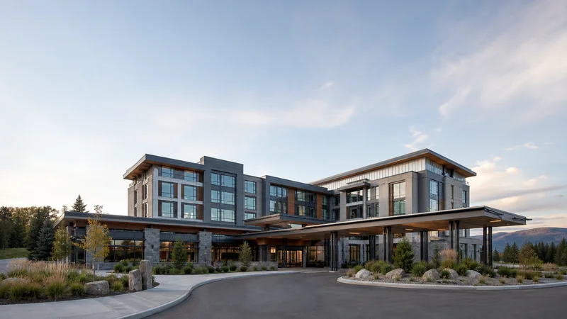 Wide establishing view of a contemporary hotel exterior, soft daylight, open sky above for overlaid text