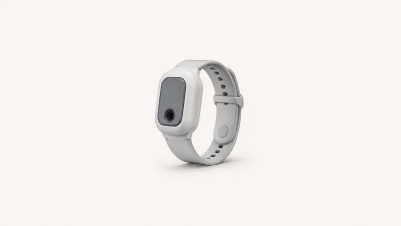 Isolated a wrist-worn clinical pulse-oximetry sensor with a silicone strap centred on a seamless pale off-white studio background, generous empty margin on every side for overlaid branding