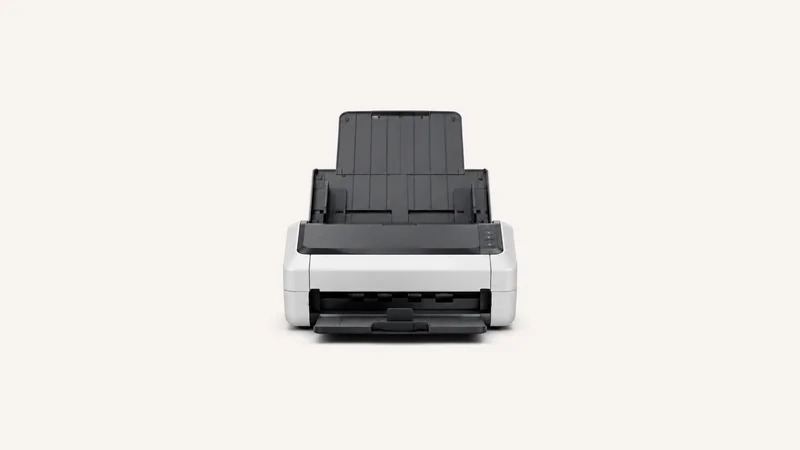 Isolated a sheet-fed desktop document scanner with a raised paper tray centred on a seamless pale off-white studio background, generous empty margin on every side for overlaid branding