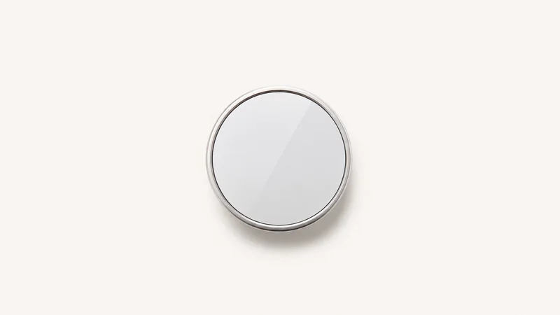 Isolated a wall-mounted smart thermostat with a blank glass face centred on a seamless pale off-white studio background, generous empty margin on every side for overlaid branding
