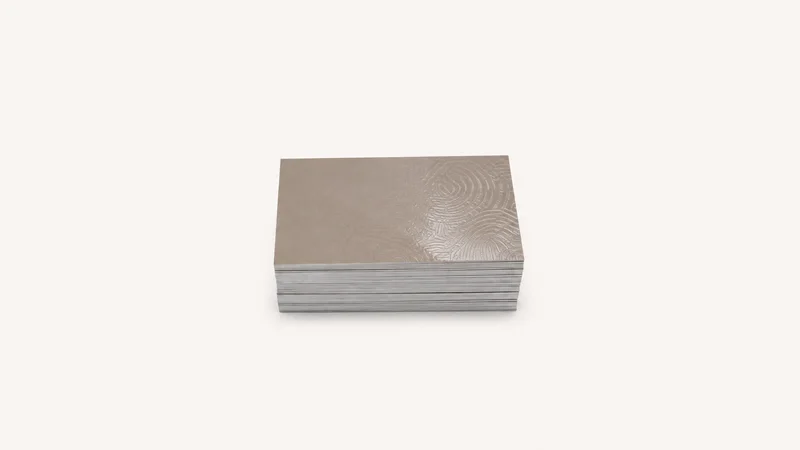 Isolated a stack of trimmed business cards with a spot-varnish finish centred on a seamless pale off-white studio background, generous empty margin on every side for overlaid branding