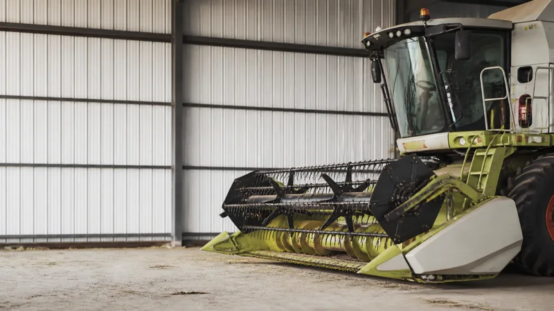 Close, clean detail of the harvester at rest in a field, soft daylight, no people in frame