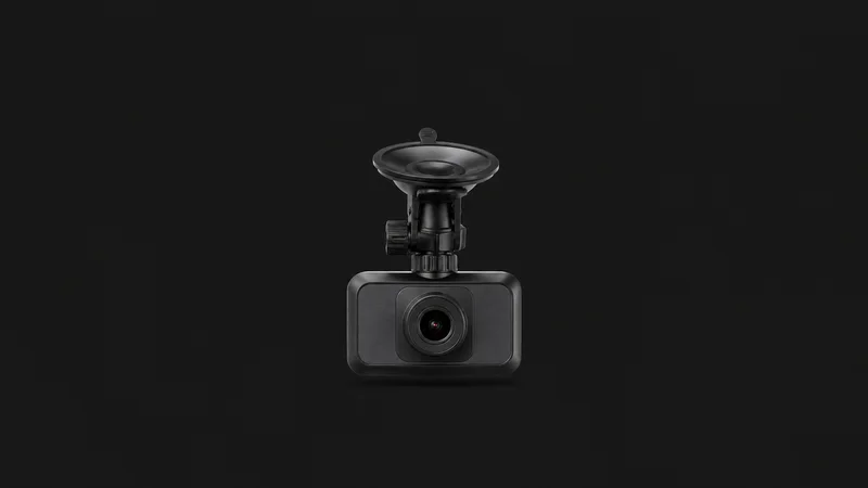 Isolated a windscreen-mounted dash camera with a suction cup and small lens centred on a seamless deep charcoal near-black studio background, generous empty margin on every side for overlaid branding