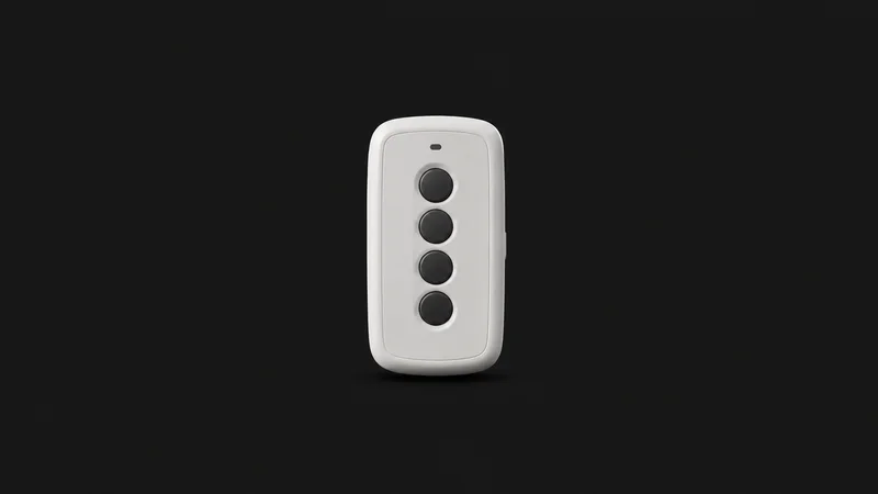 Isolated a classroom response clicker with four unmarked answer buttons centred on a seamless deep charcoal near-black studio background, generous empty margin on every side for overlaid branding