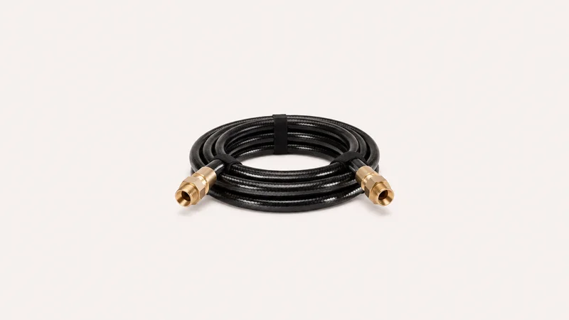 Isolated a coiled liquid-cooling tube with brass fittings centred on a seamless pale off-white studio background, generous empty margin on every side for overlaid branding