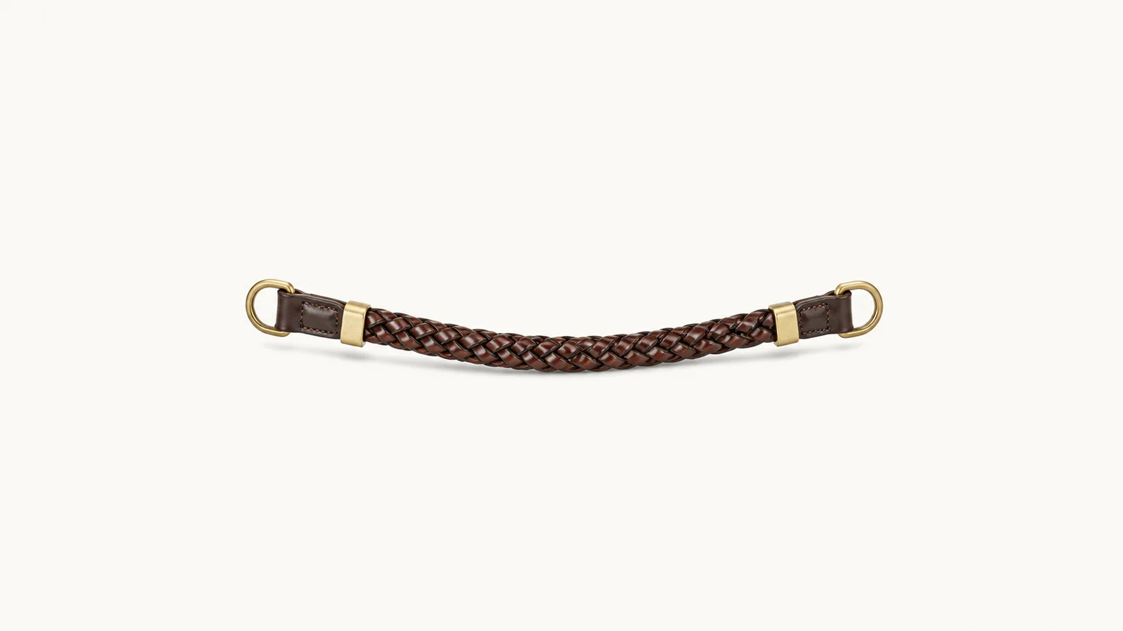 Isolated a plaited leather browband with brass fittings centred on a seamless pale off-white studio background, generous empty margin on every side for overlaid branding