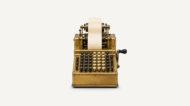 Isolated a brass-cased mechanical adding machine with a paper tape centred on a seamless pale off-white studio background, generous empty margin on every side for overlaid branding