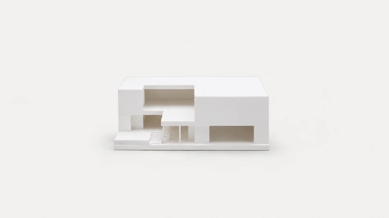 Isolated a white foam-board massing model of a simple block centred on a seamless pale off-white studio background, generous empty margin on every side for overlaid branding