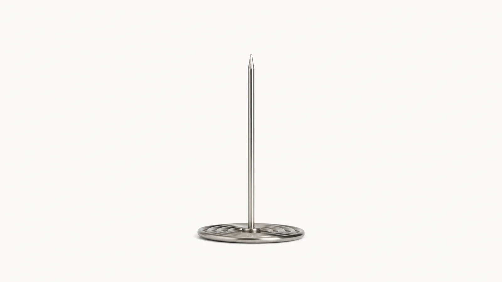 Isolated a receipt spike with a coiled base centred on a seamless pale off-white studio background, generous empty margin on every side for overlaid branding