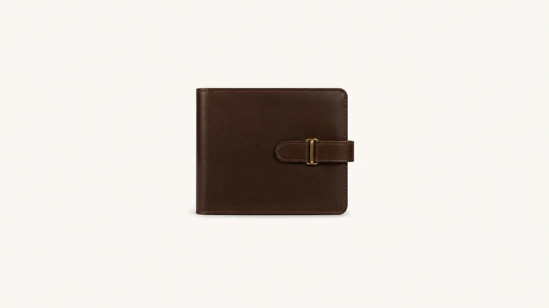 Isolated a leather-bound share certificate portfolio with a strap centred on a seamless pale off-white studio background, generous empty margin on every side for overlaid branding