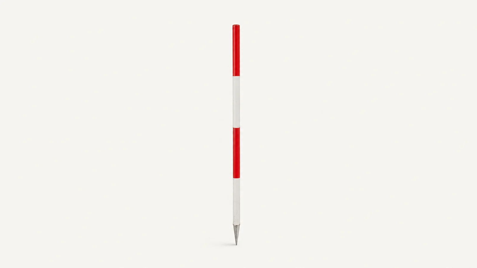 Isolated a red-and-white survey ranging pole with its steel point centred on a seamless pale off-white studio background, generous empty margin on every side for overlaid branding
