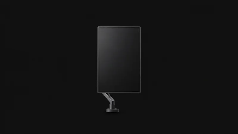 Isolated a vertical monitor on a slim arm mount centred on a seamless deep charcoal near-black studio background, generous empty margin on every side for overlaid branding
