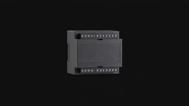Isolated a din-rail edge controller module with a row of unlabelled terminals centred on a seamless deep charcoal near-black studio background, generous empty margin on every side for overlaid branding