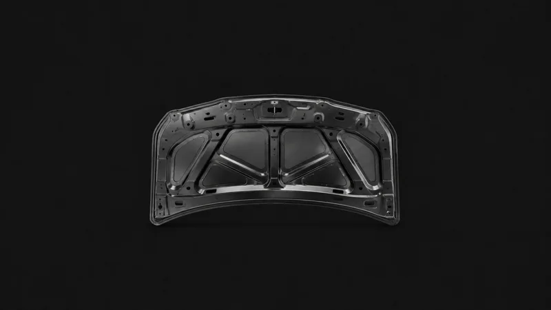 Isolated a pressed steel car bonnet inner panel with stiffening ribs centred on a seamless deep charcoal near-black studio background, generous empty margin on every side for overlaid branding