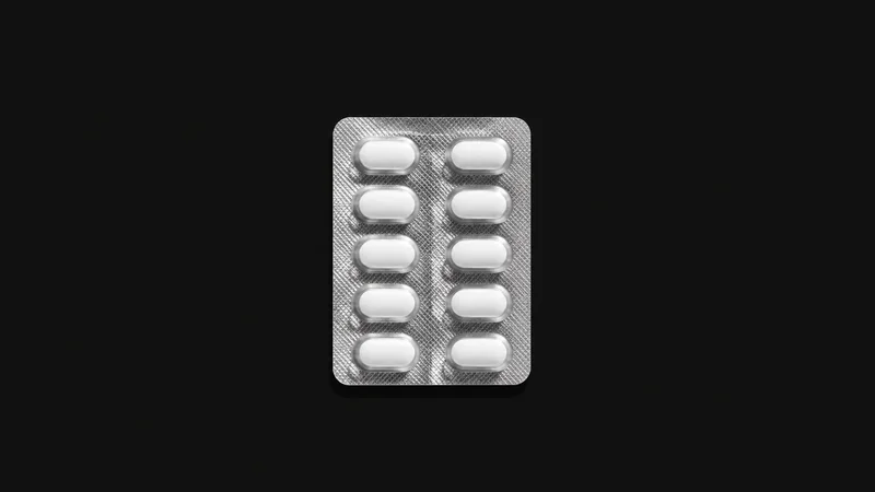 Isolated a blister pack of white oval tablets with foil backing centred on a seamless deep charcoal near-black studio background, generous empty margin on every side for overlaid branding