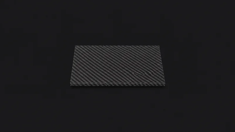 Isolated a carbon-fibre laminate panel with a visible twill weave centred on a seamless deep charcoal near-black studio background, generous empty margin on every side for overlaid branding