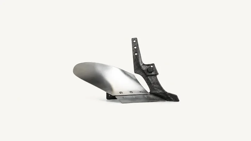 Isolated a cast-iron tractor ploughshare with a polished mouldboard centred on a seamless pale off-white studio background, generous empty margin on every side for overlaid branding