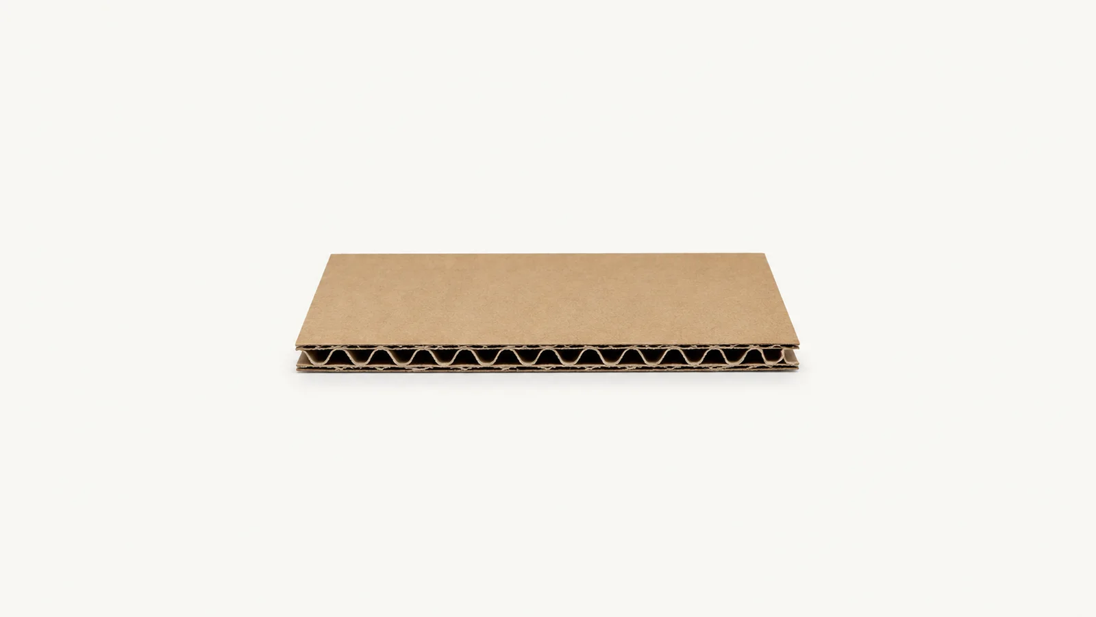 Isolated a single-wall corrugated board sample showing the fluted core centred on a seamless pale off-white studio background, generous empty margin on every side for overlaid branding