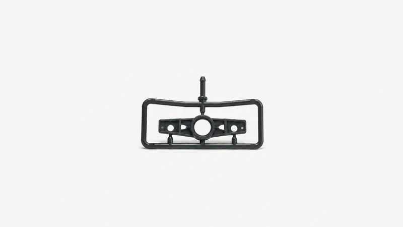 Isolated a moulded polymer part still attached to its runner and sprue centred on a seamless pale off-white studio background, generous empty margin on every side for overlaid branding