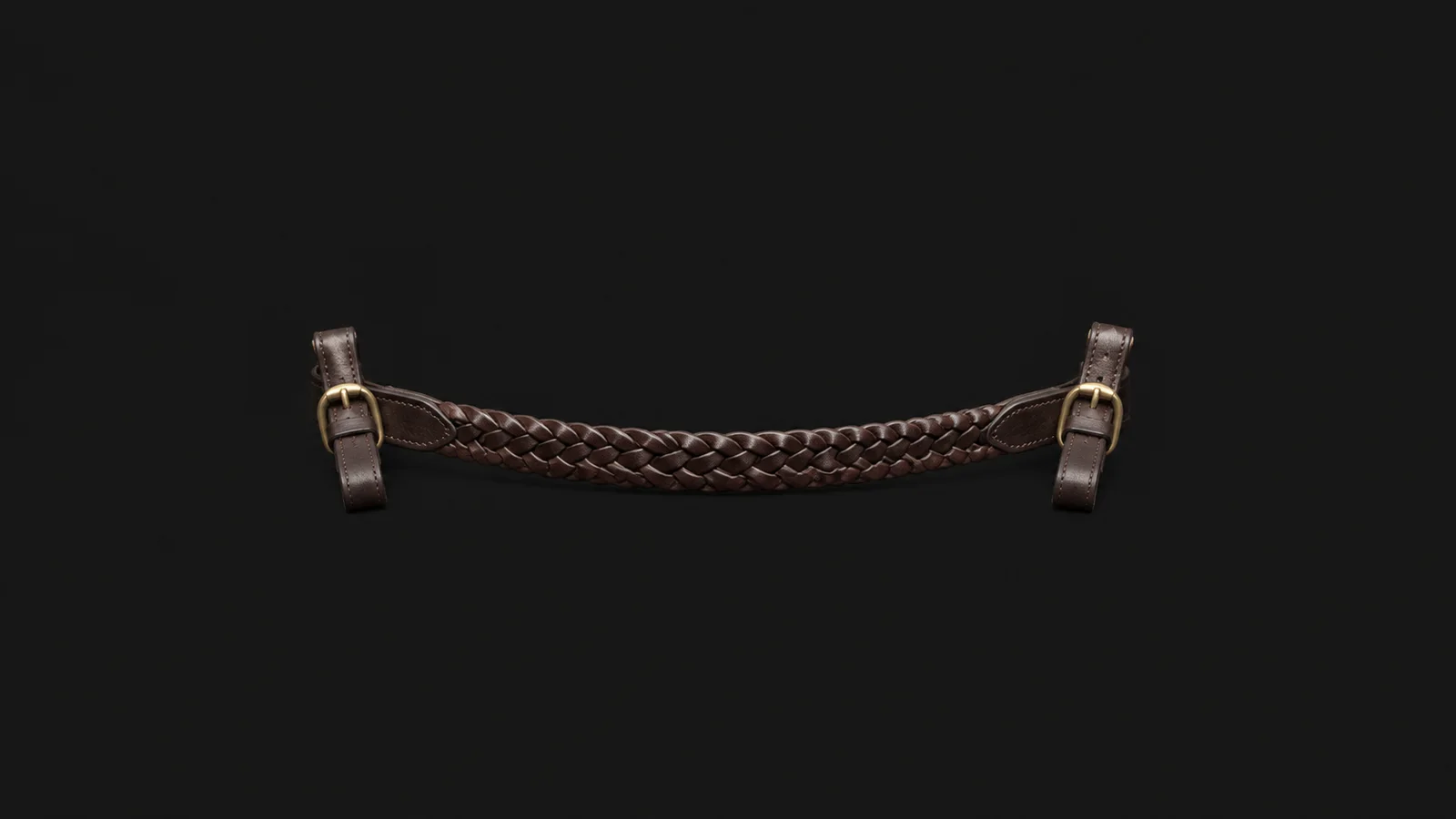 Isolated a plaited leather browband with brass fittings centred on a seamless deep charcoal near-black studio background, generous empty margin on every side for overlaid branding
