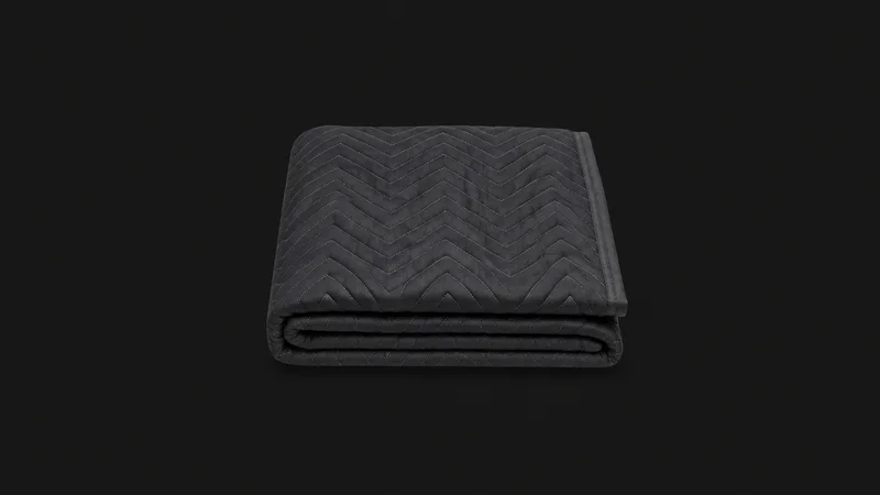Isolated a padded quilted furniture blanket folded in a neat square centred on a seamless deep charcoal near-black studio background, generous empty margin on every side for overlaid branding