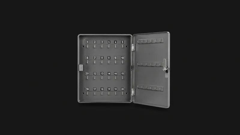 Isolated a wall-mounted steel key cabinet with numbered hooks centred on a seamless deep charcoal near-black studio background, generous empty margin on every side for overlaid branding