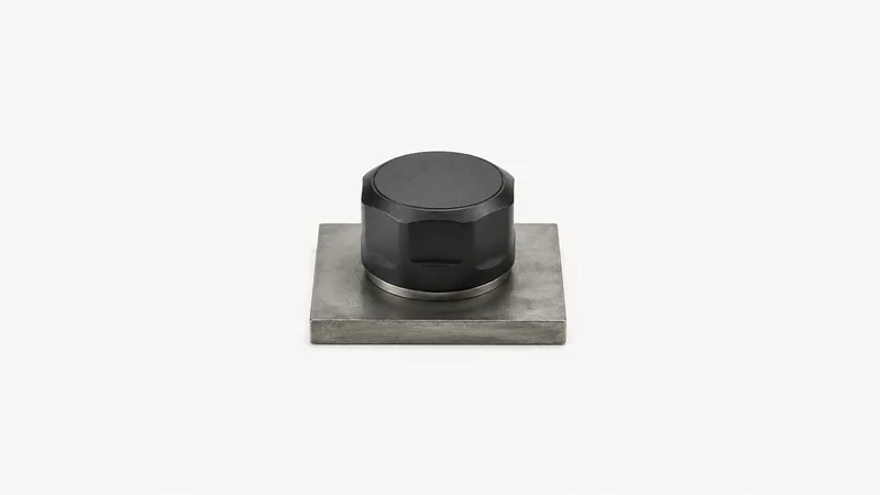 Isolated a magnetic vibration sensor puck on a bare steel plate centred on a seamless pale off-white studio background, generous empty margin on every side for overlaid branding