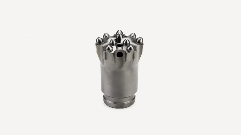 Isolated a tungsten-carbide button rock-drill bit centred on a seamless pale off-white studio background, generous empty margin on every side for overlaid branding