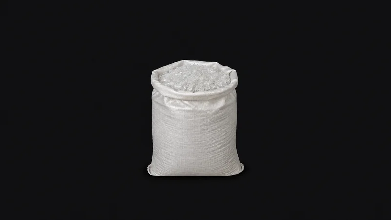 Isolated a sack of washed clear PET flakes centred on a seamless deep charcoal near-black studio background, generous empty margin on every side for overlaid branding