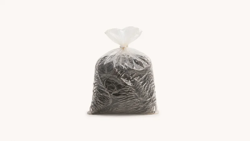Isolated a bag of coiled seat springs centred on a seamless pale off-white studio background, generous empty margin on every side for overlaid branding