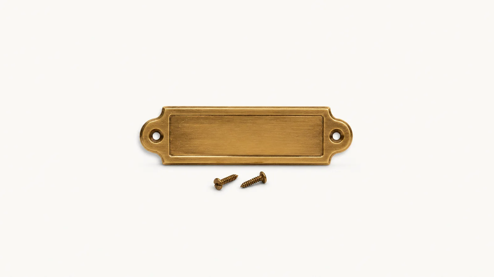 Isolated a brass door number plate with two loose screws centred on a seamless pale off-white studio background, generous empty margin on every side for overlaid branding
