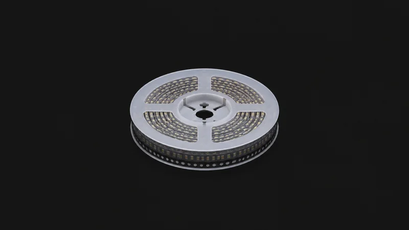 Isolated a reel of surface-mount capacitors on tape centred on a seamless deep charcoal near-black studio background, generous empty margin on every side for overlaid branding