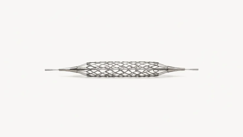 Isolated a nitinol vascular stent expanded on a mandrel centred on a seamless pale off-white studio background, generous empty margin on every side for overlaid branding