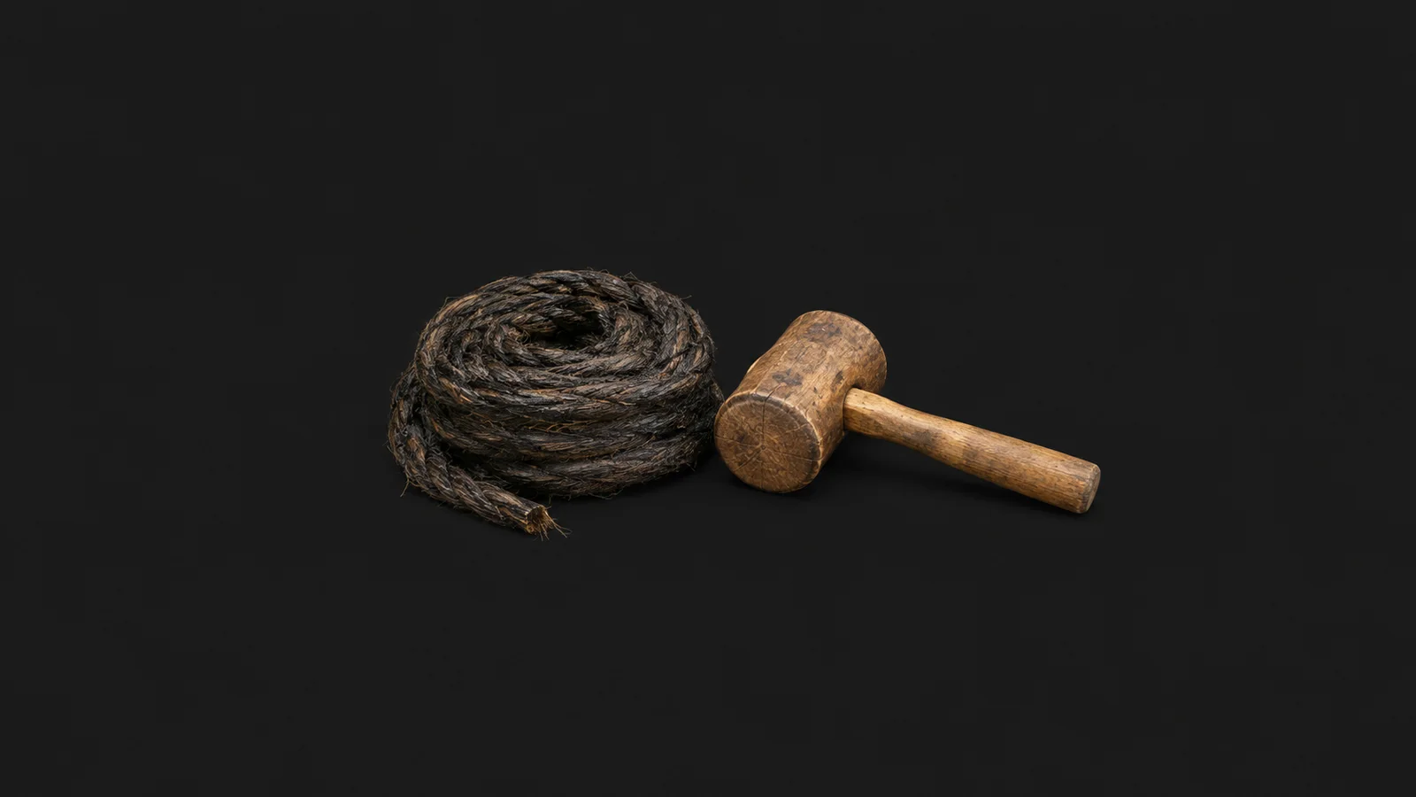 Isolated a coil of tarred hemp caulking cotton beside a caulking mallet centred on a seamless deep charcoal near-black studio background, generous empty margin on every side for overlaid branding