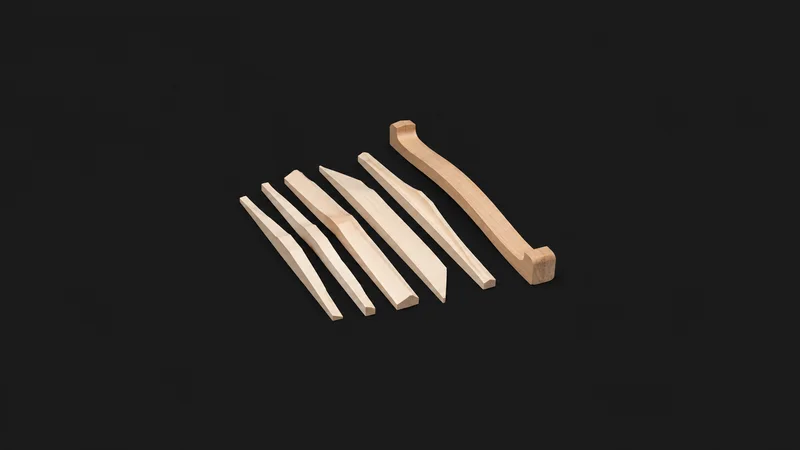 Isolated a set of loose spruce brace bars laid beside a wooden go-bar centred on a seamless deep charcoal near-black studio background, generous empty margin on every side for overlaid branding