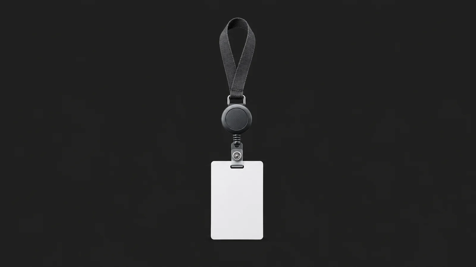Isolated a lanyard reel with a blank identity card centred on a seamless deep charcoal near-black studio background, generous empty margin on every side for overlaid branding