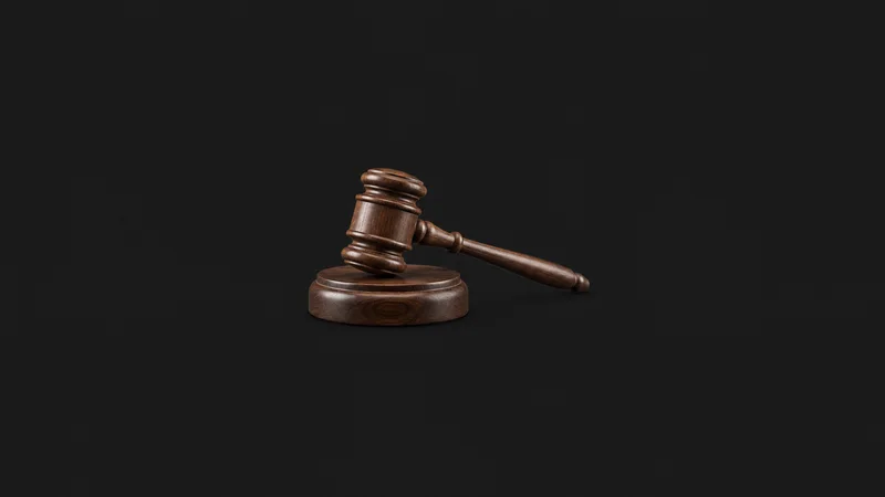 Isolated a wooden gavel and striking block on their own centred on a seamless deep charcoal near-black studio background, generous empty margin on every side for overlaid branding
