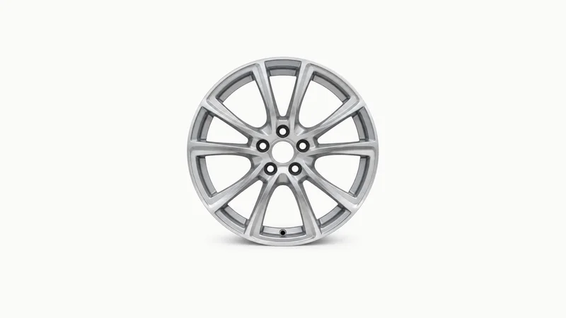 Isolated a car alloy wheel with an unpainted machined face centred on a seamless pale off-white studio background, generous empty margin on every side for overlaid branding
