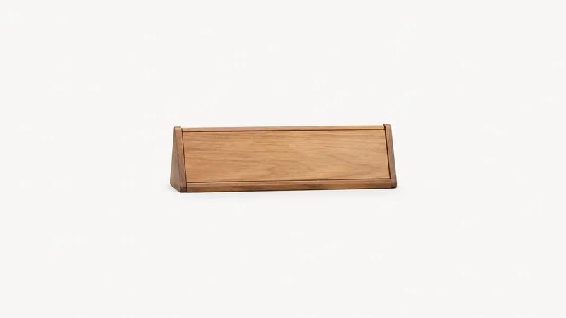 Isolated a wooden desk name-plate holder with no name centred on a seamless pale off-white studio background, generous empty margin on every side for overlaid branding