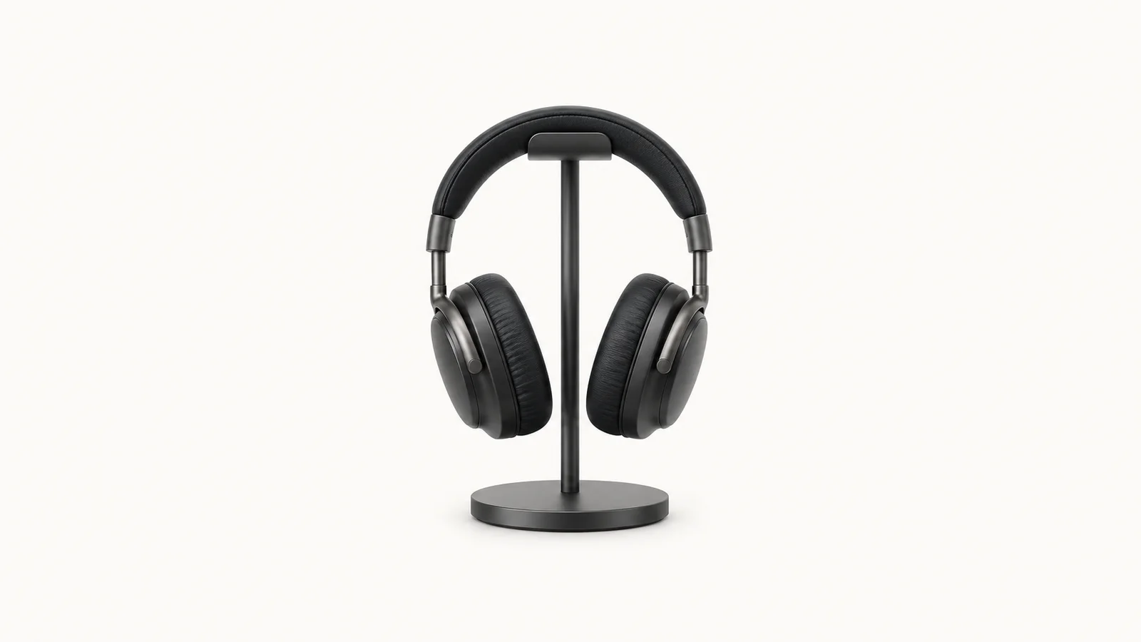Isolated a pair of closed-back monitoring headphones on a stand centred on a seamless pale off-white studio background, generous empty margin on every side for overlaid branding