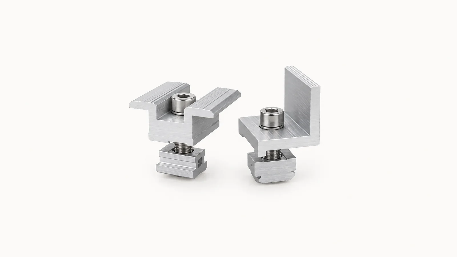 Isolated an aluminium mid-clamp and end-clamp set for panel rails centred on a seamless pale off-white studio background, generous empty margin on every side for overlaid branding