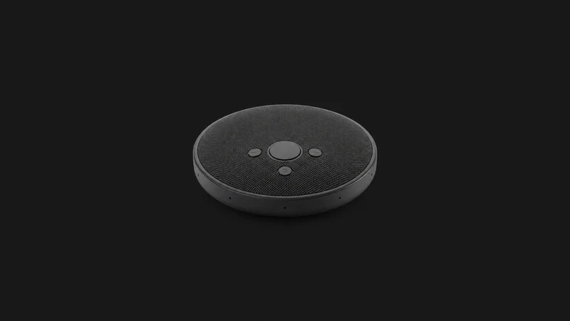 Isolated a wireless conference speakerphone with a matte grille centred on a seamless deep charcoal near-black studio background, generous empty margin on every side for overlaid branding