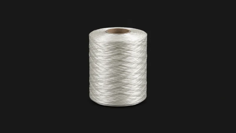 Isolated a spool of glass-fibre roving centred on a seamless deep charcoal near-black studio background, generous empty margin on every side for overlaid branding
