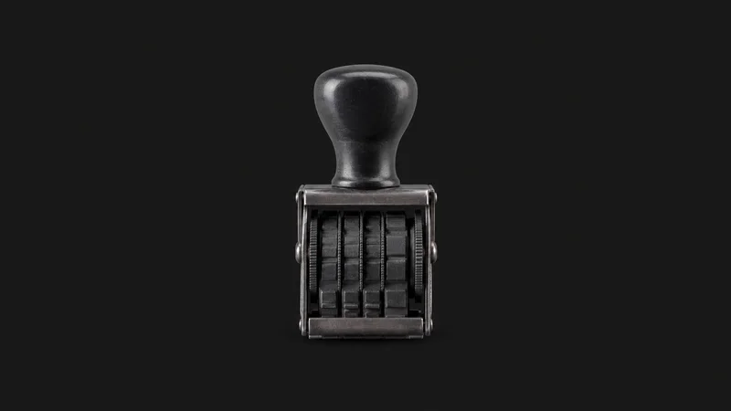 Isolated a rubber date stamp with a rotating band centred on a seamless deep charcoal near-black studio background, generous empty margin on every side for overlaid branding