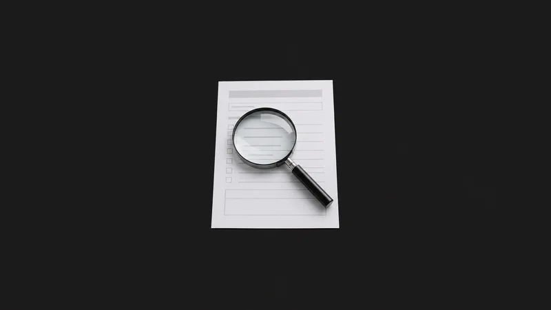Isolated a magnifying glass resting on a blank paper form centred on a seamless deep charcoal near-black studio background, generous empty margin on every side for overlaid branding
