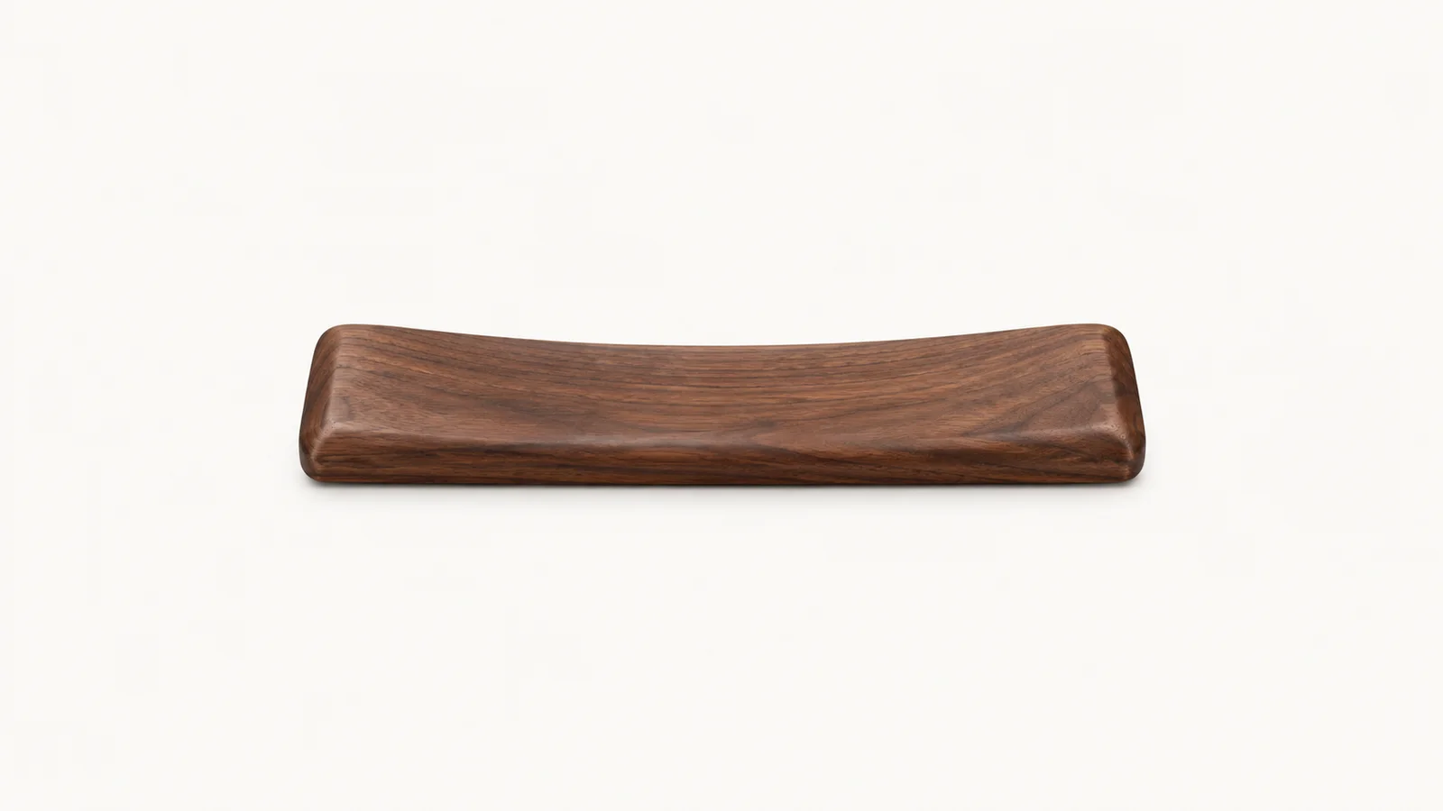Isolated a wrist rest of oiled walnut centred on a seamless pale off-white studio background, generous empty margin on every side for overlaid branding