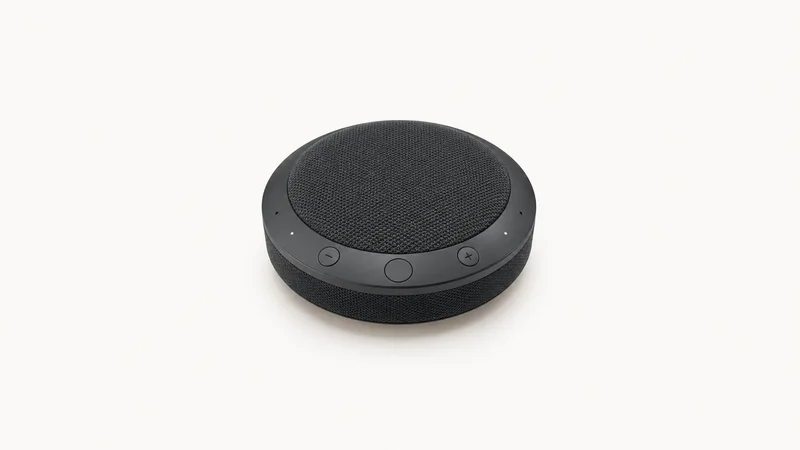 Isolated a wireless conference speakerphone puck for remote interviews centred on a seamless pale off-white studio background, generous empty margin on every side for overlaid branding