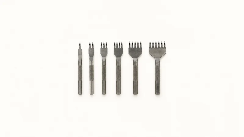 Isolated a set of pricking irons with diamond-shaped teeth laid in size order centred on a seamless pale off-white studio background, generous empty margin on every side for overlaid branding