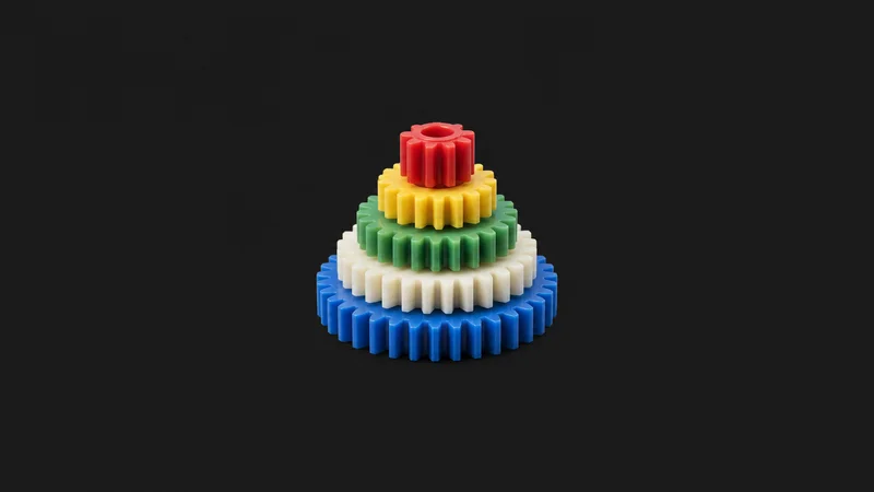 Isolated a stack of moulded plastic gears in bright colours centred on a seamless deep charcoal near-black studio background, generous empty margin on every side for overlaid branding