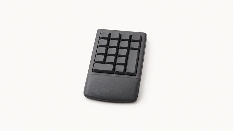 Isolated a compact ten-key numeric keypad with a wrist rest centred on a seamless pale off-white studio background, generous empty margin on every side for overlaid branding
